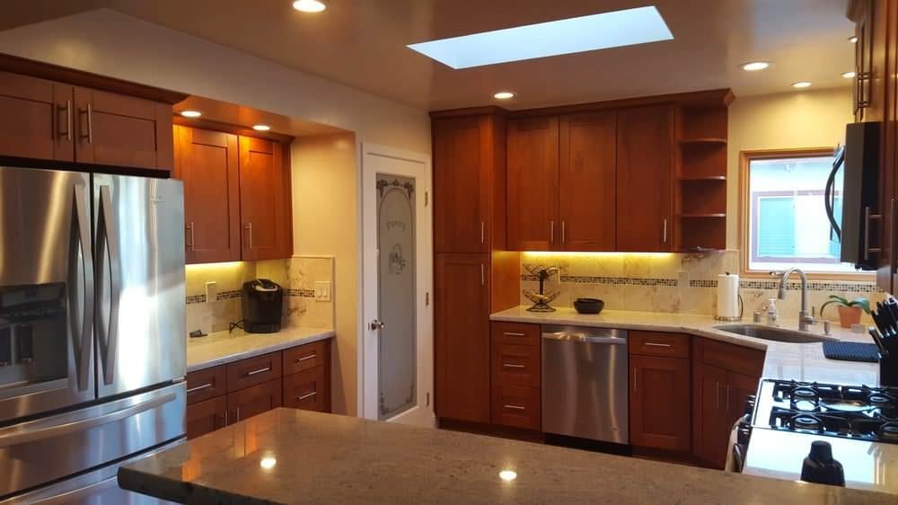 Warm wood kitchen with skylight and stainless steel appliances