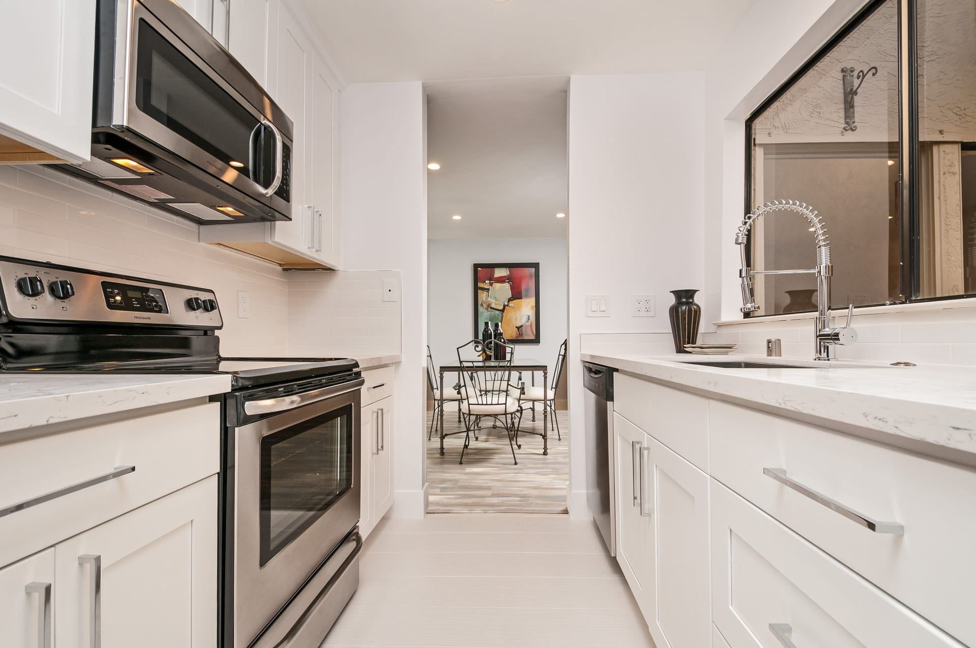 Bright white galley kitchen with dining area