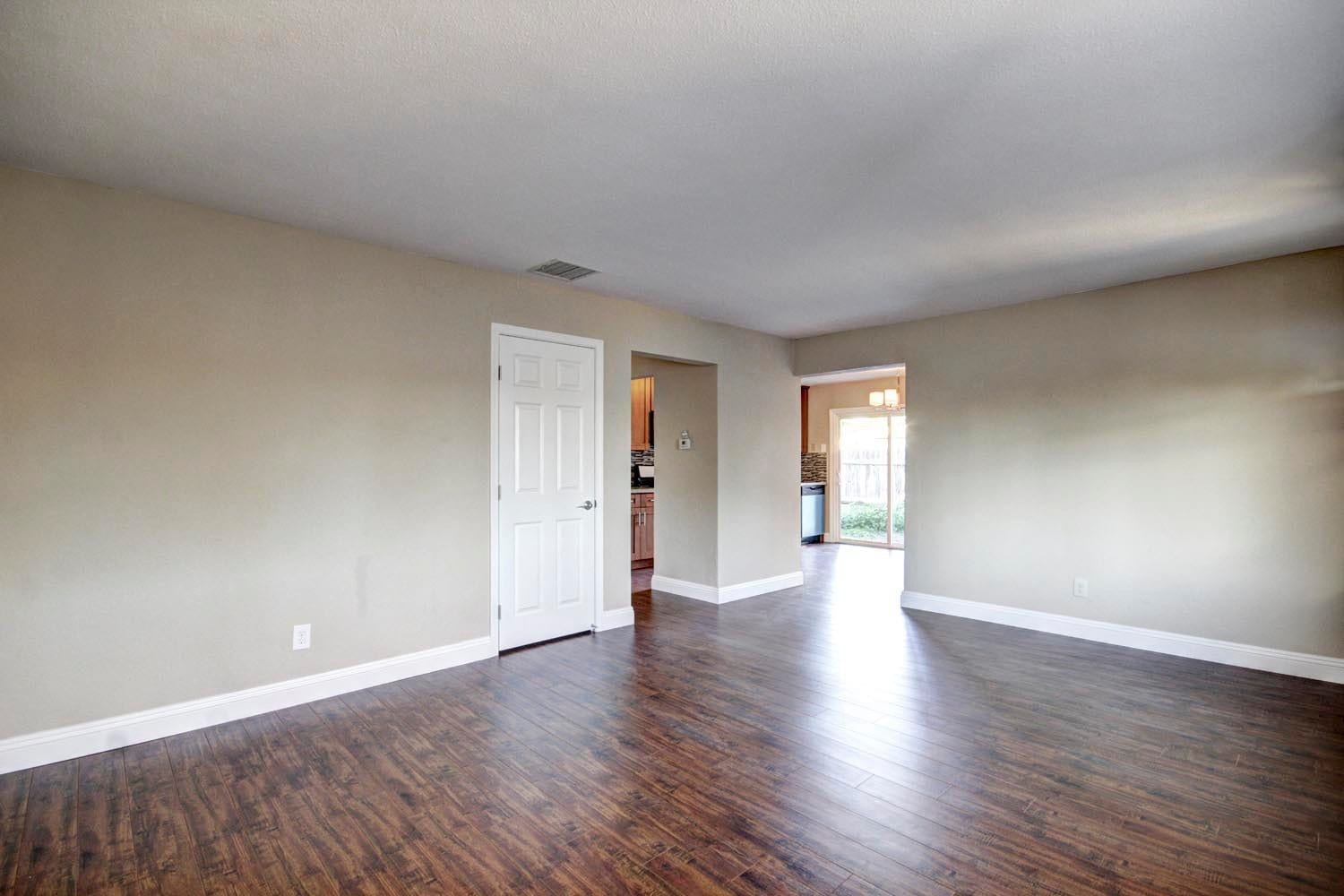 Modern open living area with dark wood look flooring pacifica