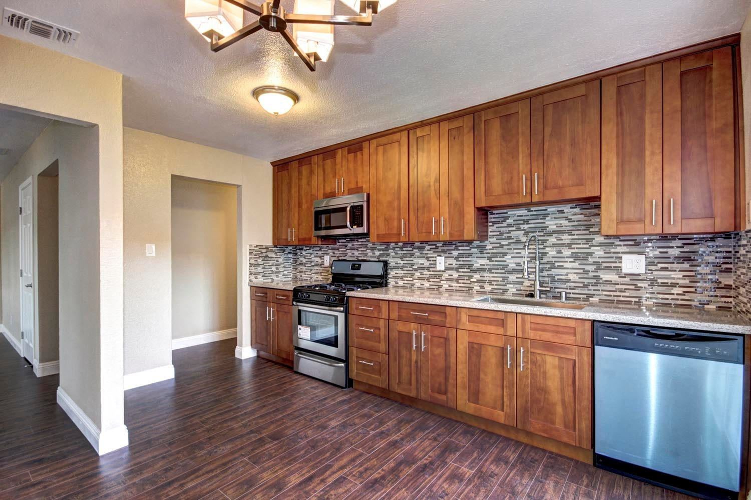 Warm wood kitchen with full height cabinetry and mosaic backsplash