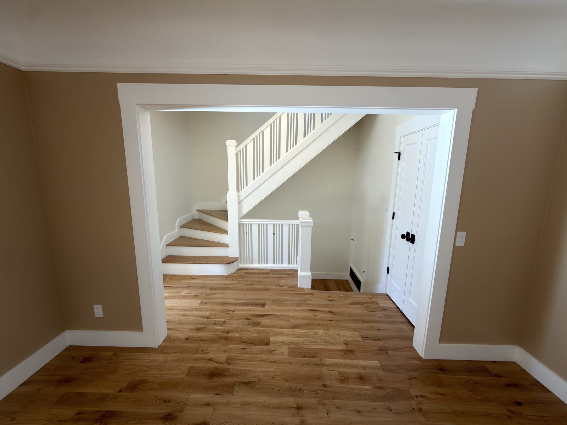 Wood staircase with white railings and wide interior opening