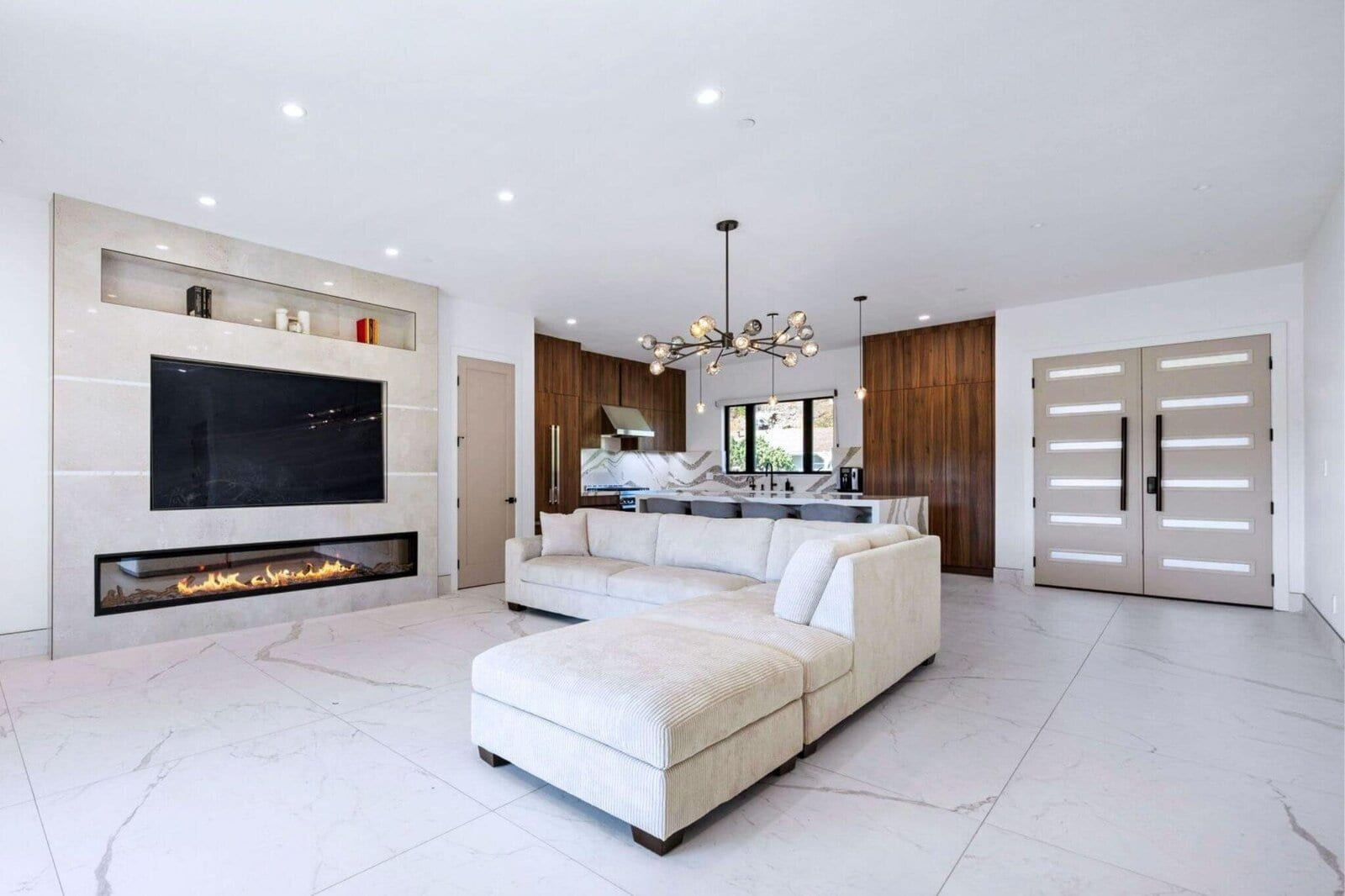 Open living room with linear fireplace and luxury kitchen