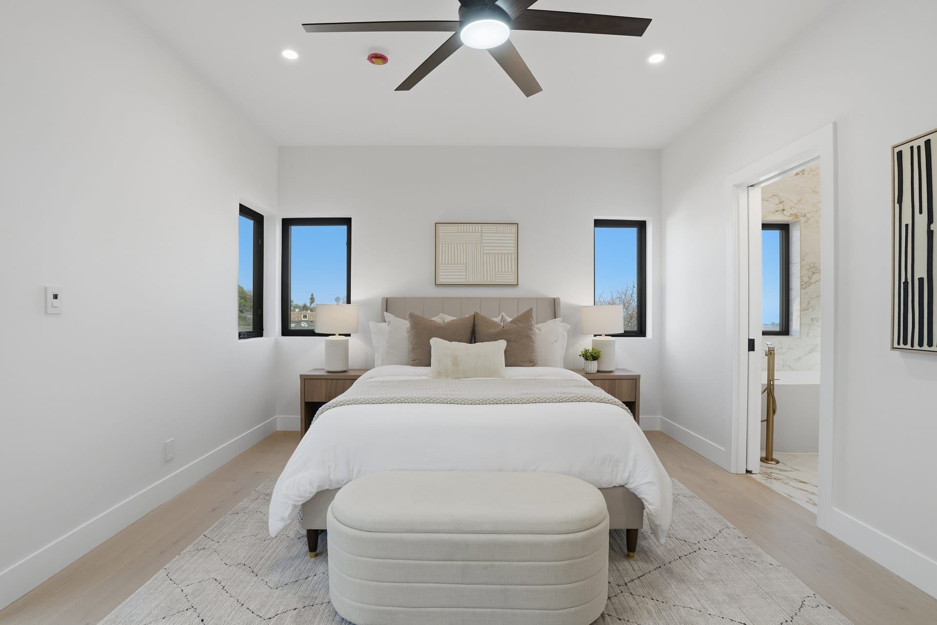 Primary bedroom with vaulted ceiling and black framed windows