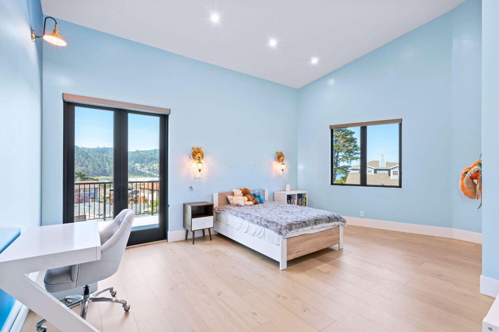 Light filled bedroom with balcony access and soft blue walls