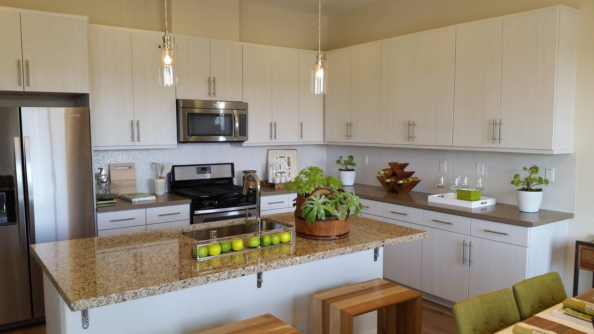 Light wood kitchen with granite island and pendant lights