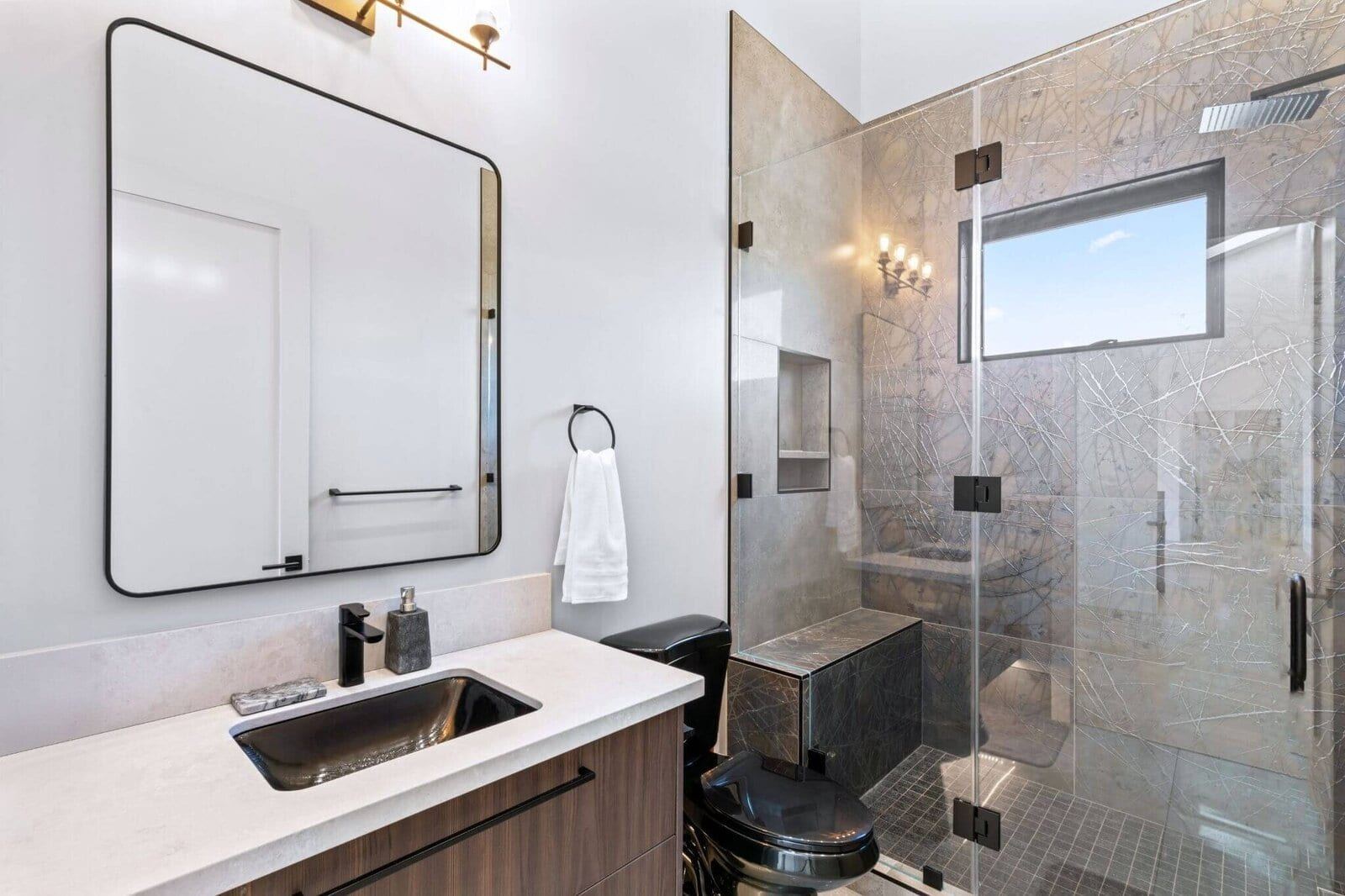 Modern walk in shower with built in bench and black fixtures