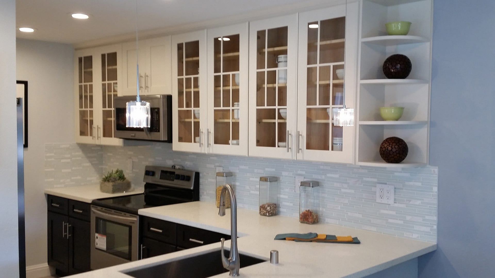 Black and white kitchen with glass front cabinets