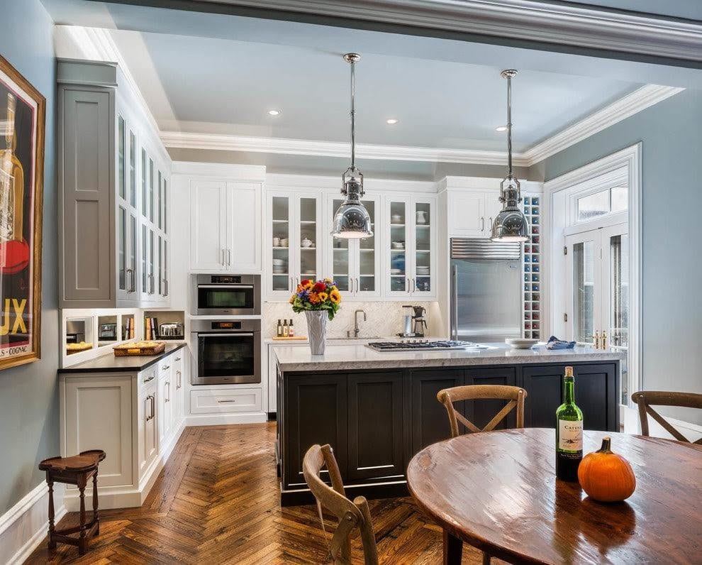 Transitional white kitchen with dark island and herringbone wood floor