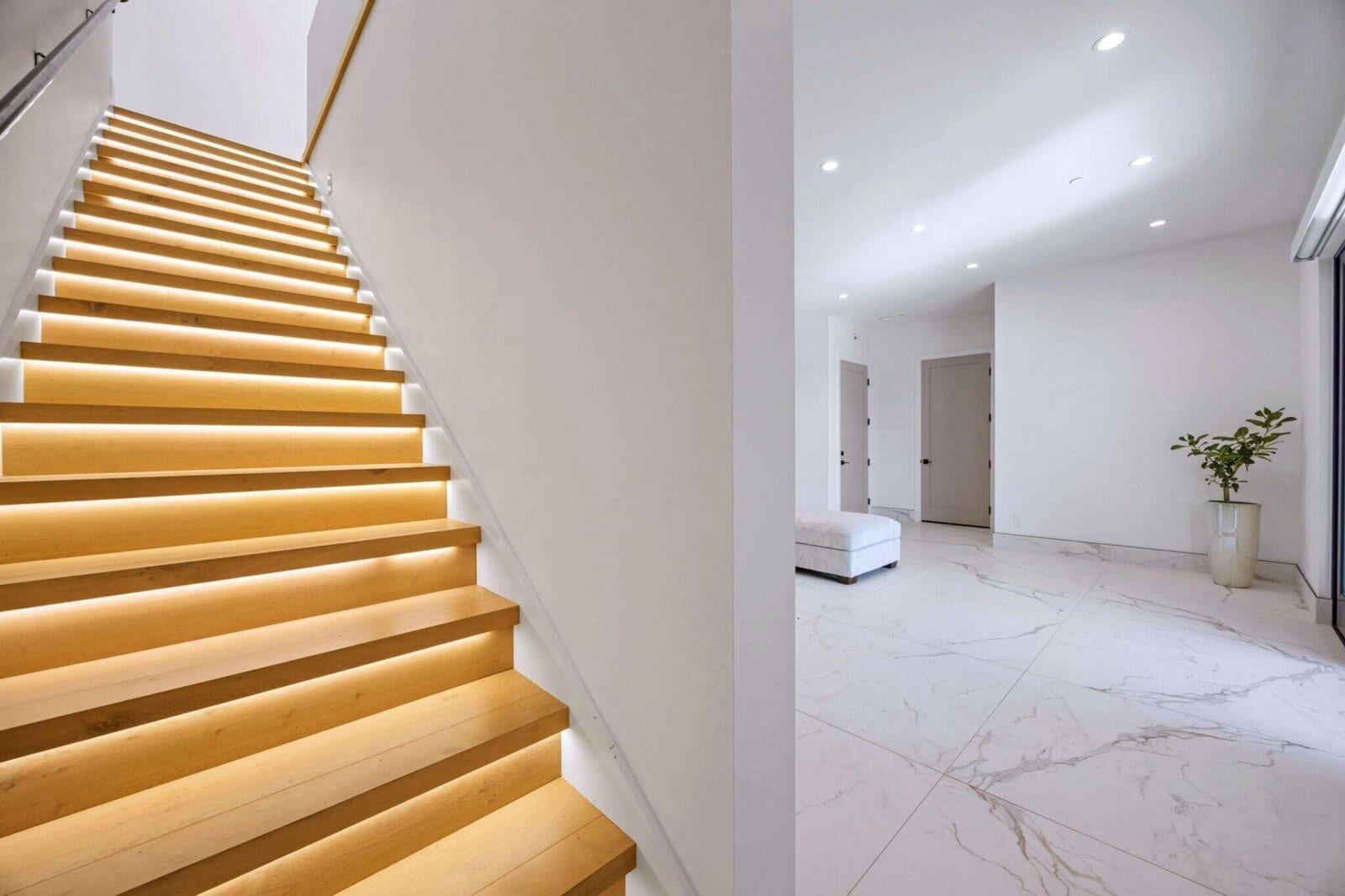 Illuminated floating wood staircase with integrated step lighting
