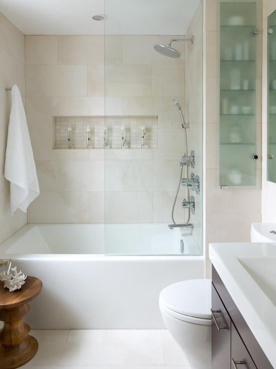 Neutral tub shower bathroom with glass panel and rain shower