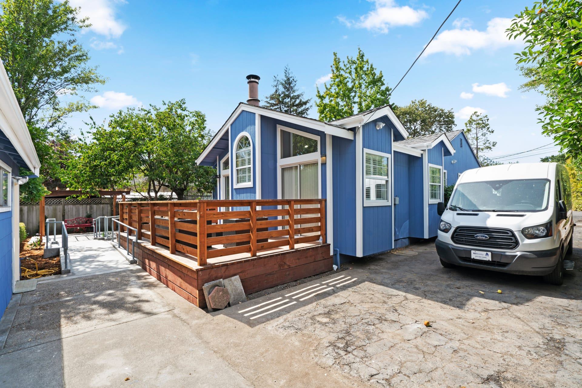 Accessible blue home exterior with wheelchair ramp and wood deck novato