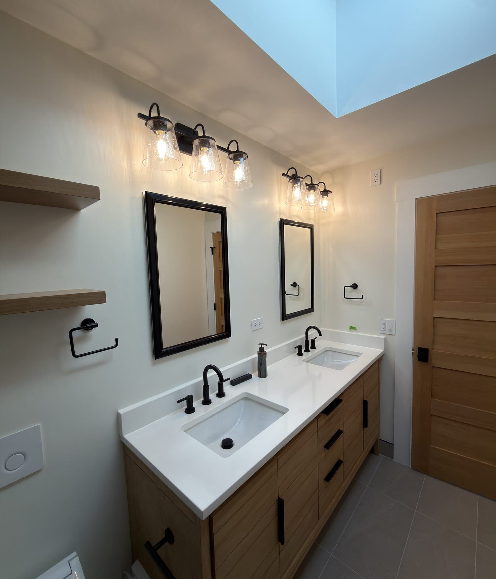 Skylit bathroom with a natural wood double vanity