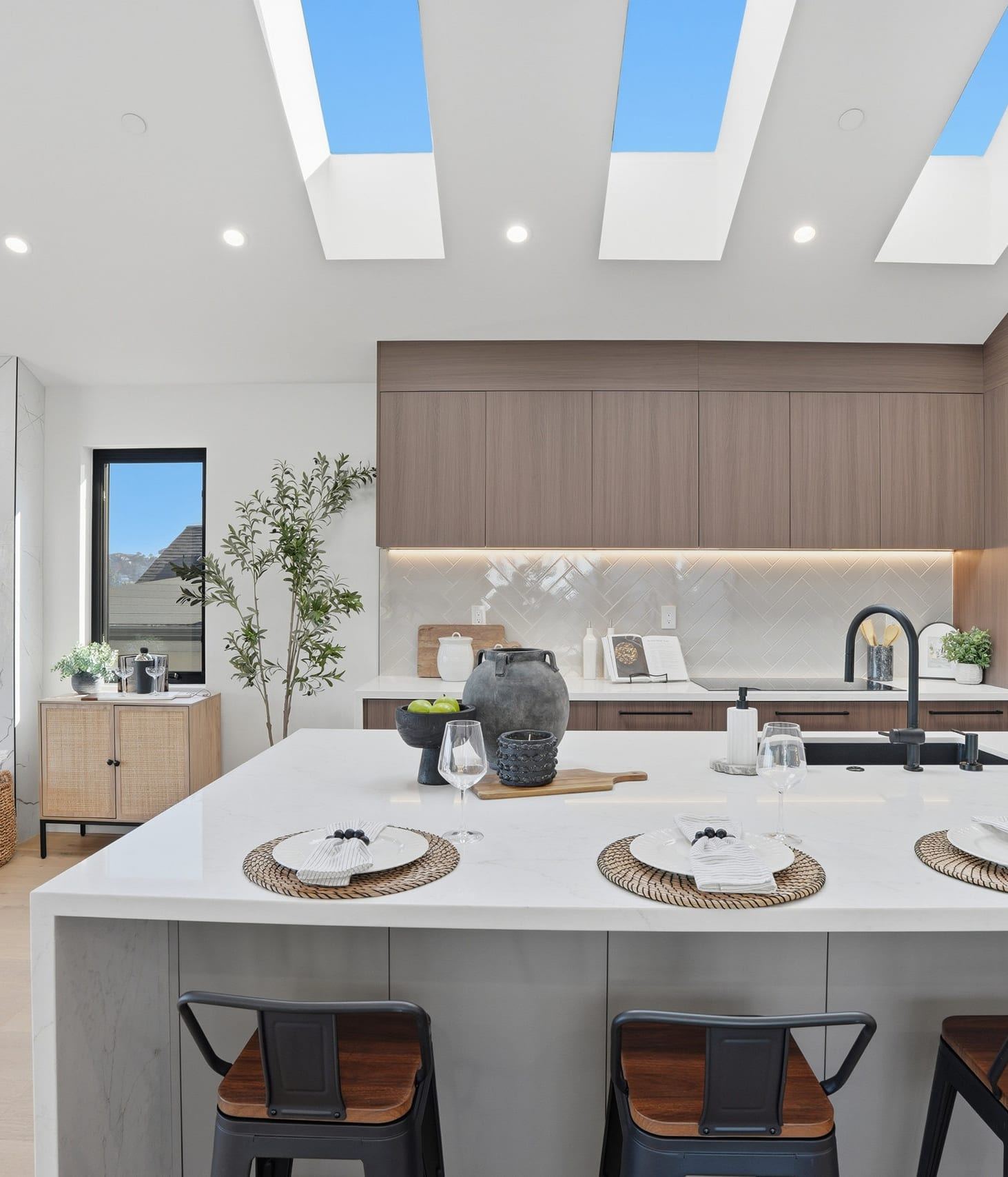 Modern wood kitchen with a waterfall island under triple skylights