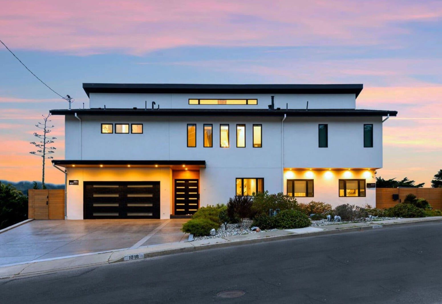 Modern multi-level home exterior at sunset in Pacifica