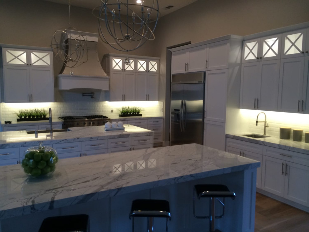 Large White Kitchen with Double Islands and Illuminated Cabinets